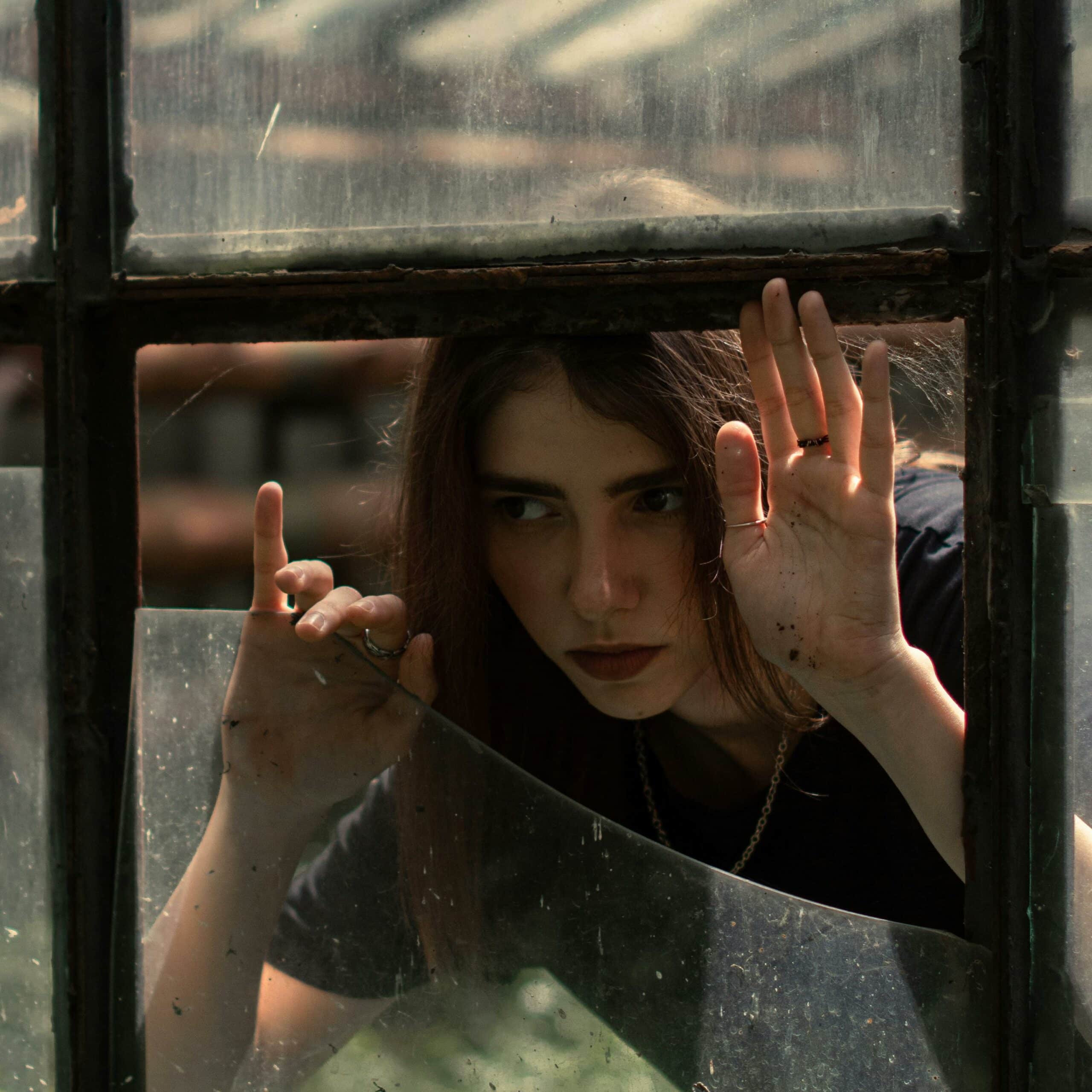 Woman peeking through a broken window