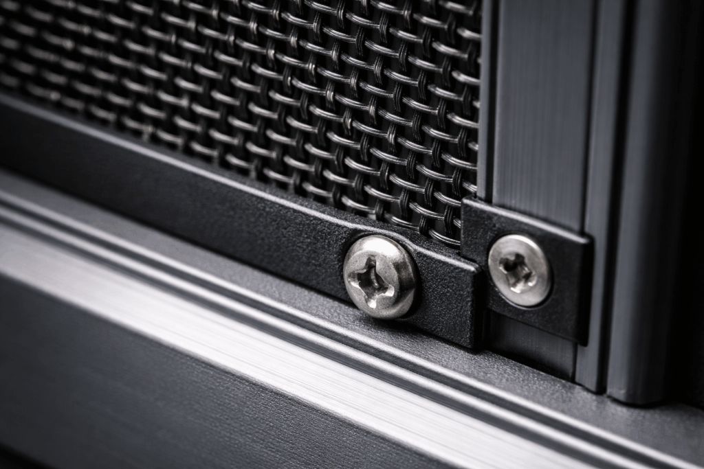 Close-up detail of stainless steel security mesh clamped securely into an aluminum frame.